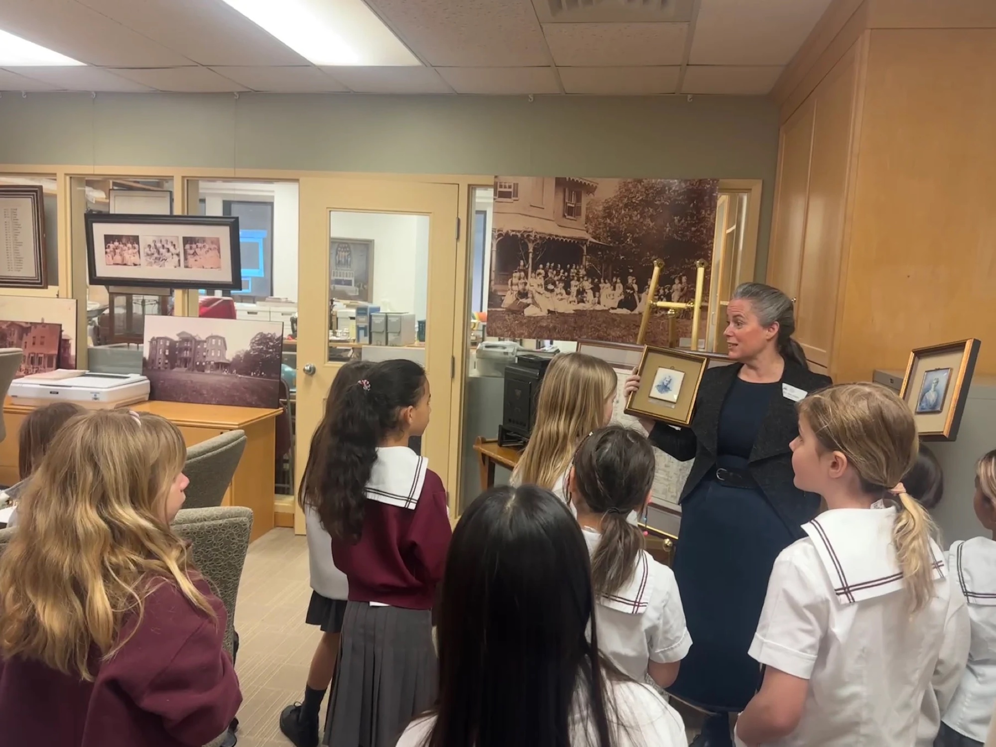 An archivist sharing framed historical images