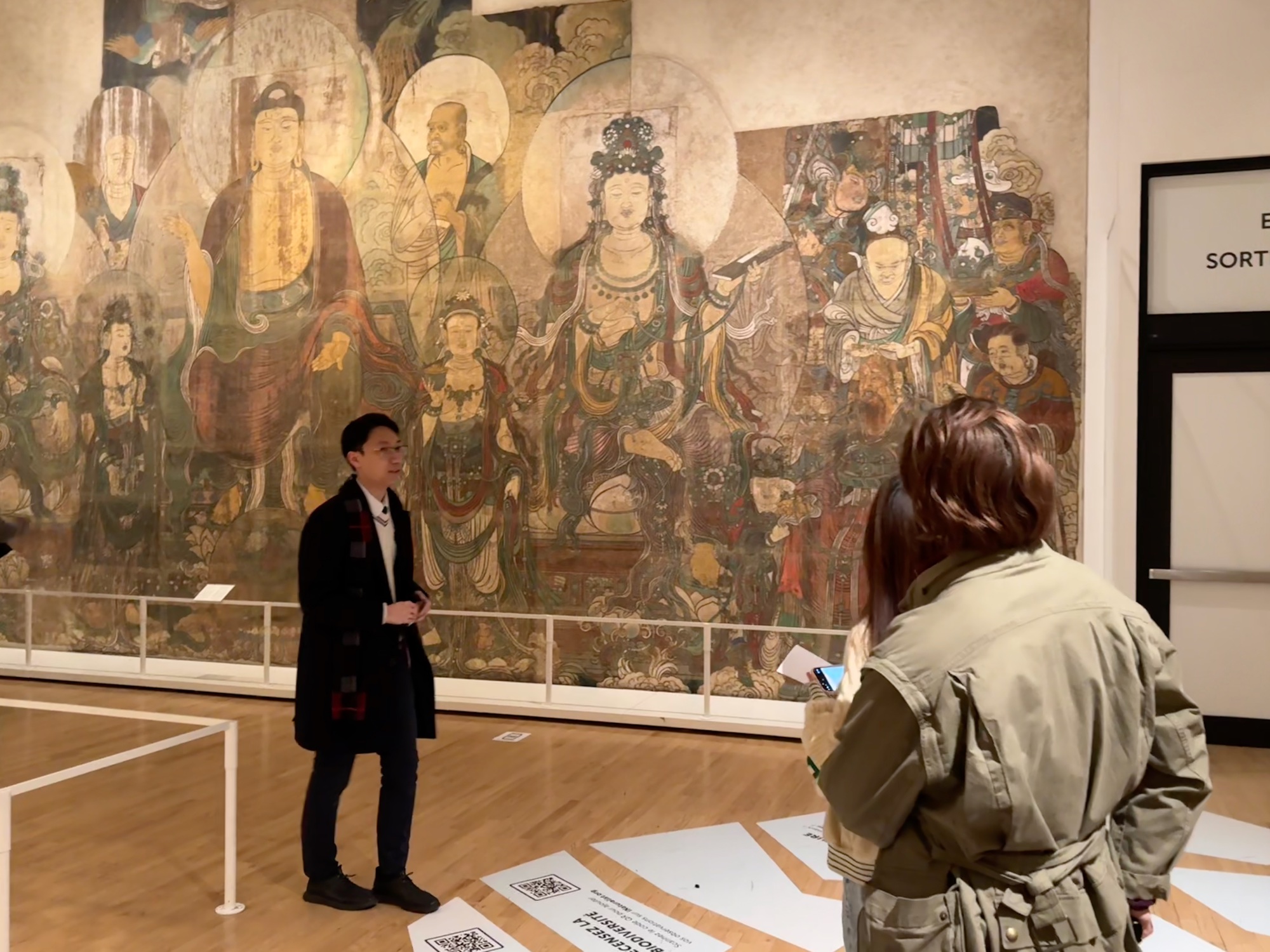 Club members in front of a Buddhist mural