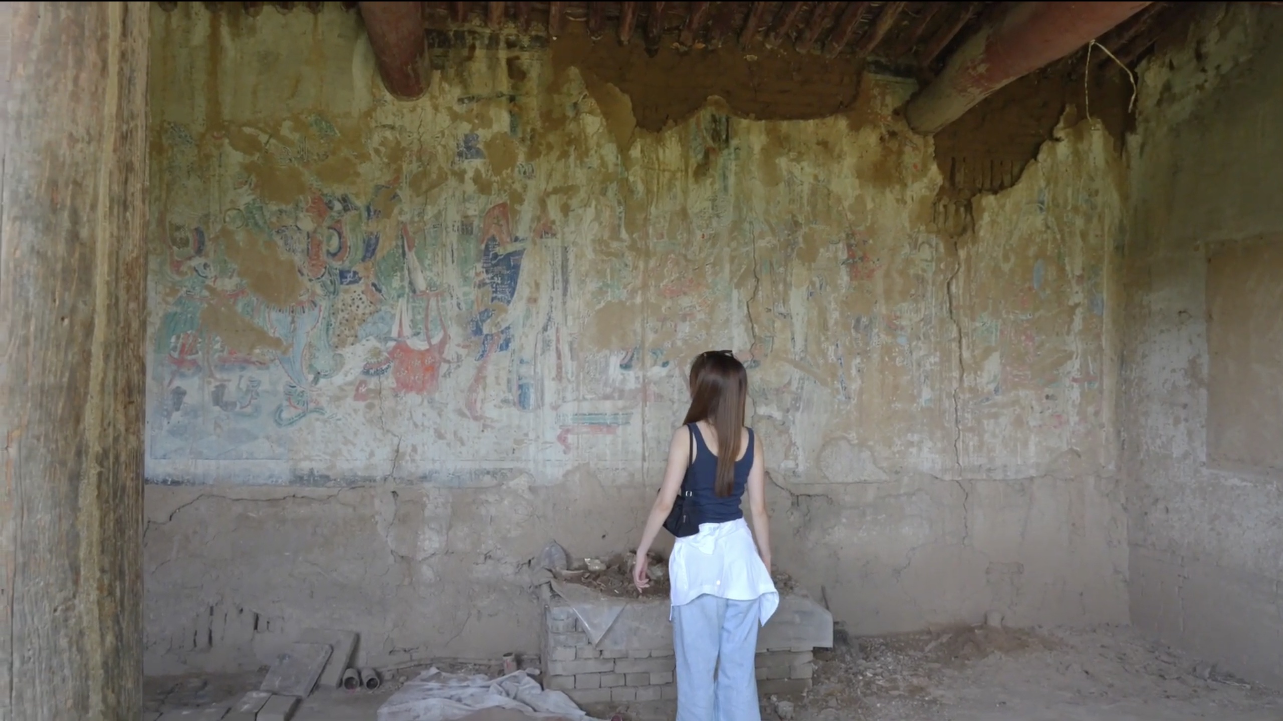 Examining weathered murals inside a historic building