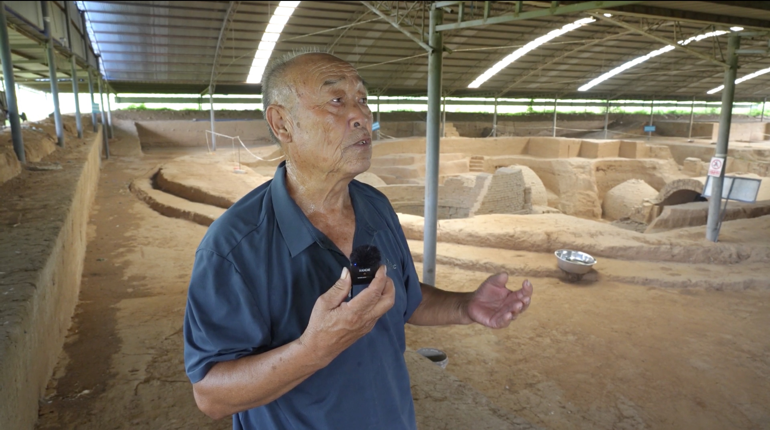 An interview participant speaking at a covered excavation site
